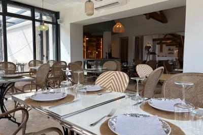 Vue aérienne d'un terrain de tennis rouge entouré de forêt, avec une petite mare et des prairies avoisinantes.