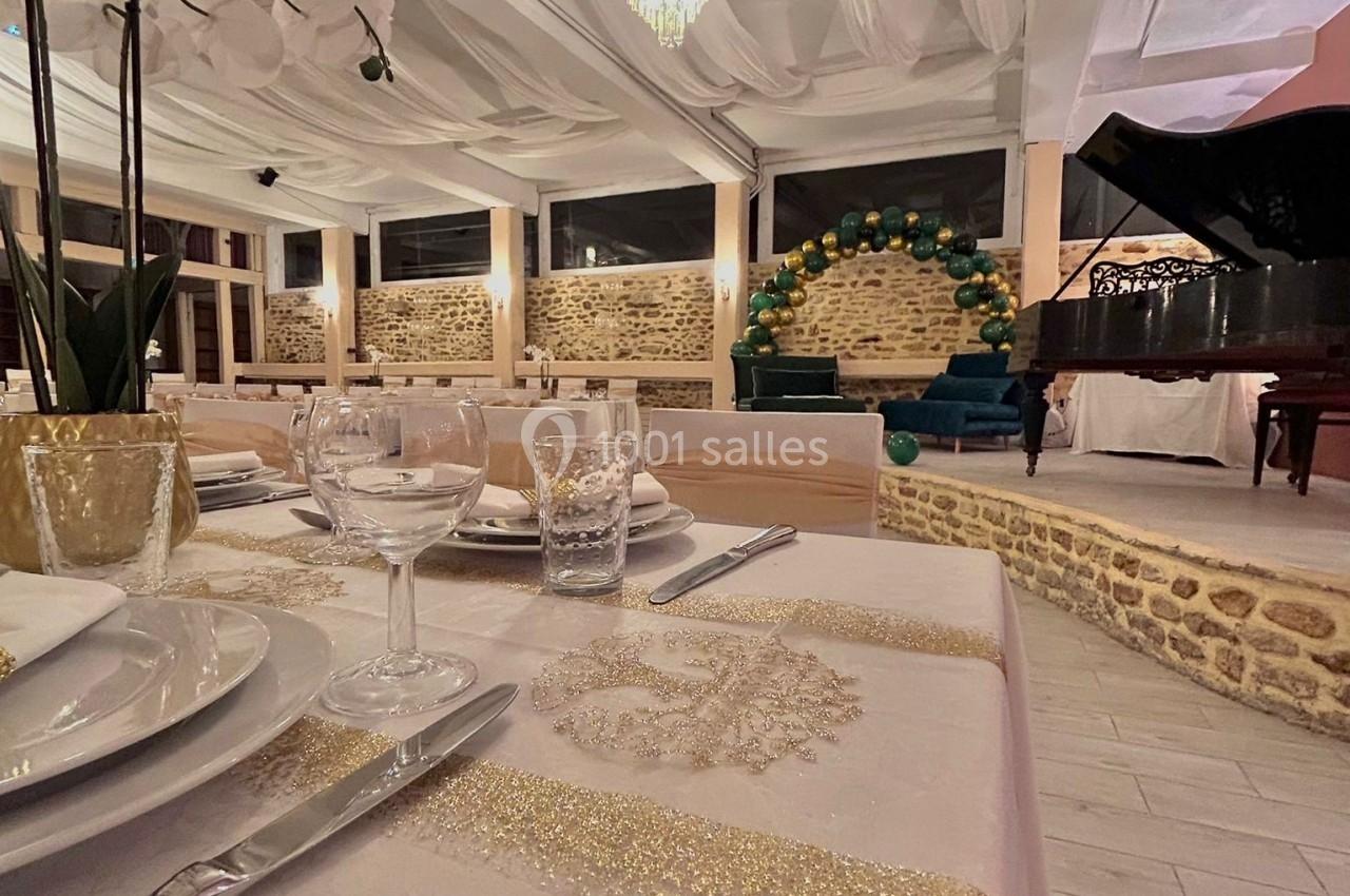 Salle de réception élégante avec tables décorées, orchidée blanche au premier plan et piano à queue en arrière-plan.