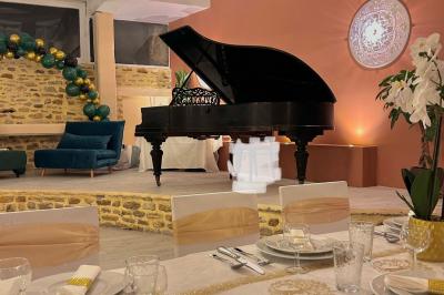 Petit jardin avec une table et des chaises roses, entouré de plantes et d'un puits en pierre devant des maisons.