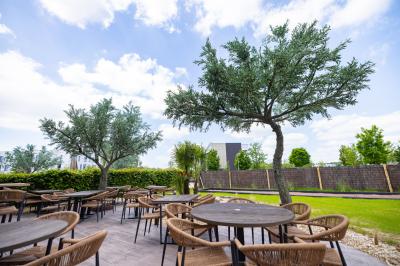 Salle de restaurant chaleureuse avec des tables dressées, une cave à vin visible et un serveur en action.