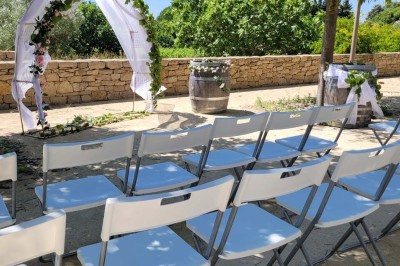 Salle de réunion lumineuse avec tables en U, chaises en bois, tonneau décoratif et étagères murales garnies de bouteilles.