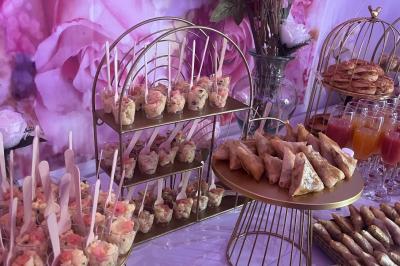 Macaron rouge garni de crème, framboise et groseilles, présenté sur une assiette blanche avec une cuillère dorée.