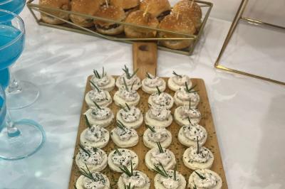 Macaron rouge garni de crème, framboise et groseilles, présenté sur une assiette blanche avec une cuillère dorée.