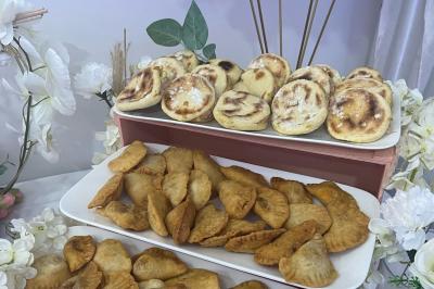 Macaron rouge garni de crème, framboise et groseilles, présenté sur une assiette blanche avec une cuillère dorée.