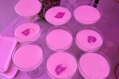 Macaron rouge garni de crème, framboise et groseilles, présenté sur une assiette blanche avec une cuillère dorée.