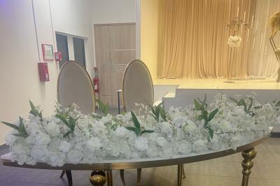 Macaron rouge garni de crème, framboise et groseilles, présenté sur une assiette blanche avec une cuillère dorée.