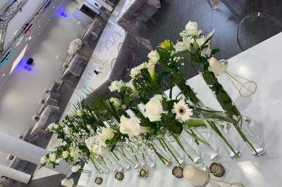 Macaron rouge garni de crème, framboise et groseilles, présenté sur une assiette blanche avec une cuillère dorée.