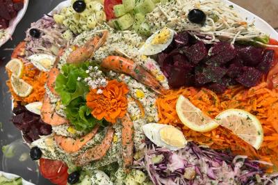 Macaron rouge garni de crème, framboise et groseilles, présenté sur une assiette blanche avec une cuillère dorée.