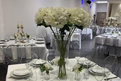 Macaron rouge garni de crème, framboise et groseilles, présenté sur une assiette blanche avec une cuillère dorée.