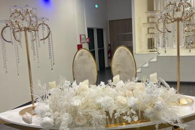 Macaron rouge garni de crème, framboise et groseilles, présenté sur une assiette blanche avec une cuillère dorée.