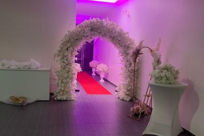 Macaron rouge garni de crème, framboise et groseilles, présenté sur une assiette blanche avec une cuillère dorée.