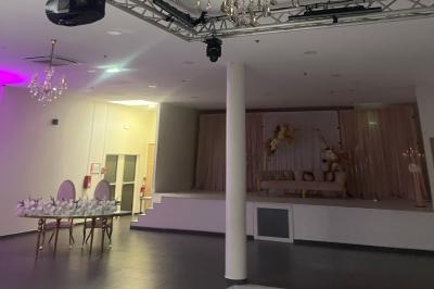 Macaron rouge garni de crème, framboise et groseilles, présenté sur une assiette blanche avec une cuillère dorée.