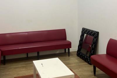 Macaron rouge garni de crème, framboise et groseilles, présenté sur une assiette blanche avec une cuillère dorée.