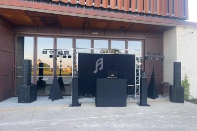 Installation de matériel de sonorisation et d'éclairage devant un bâtiment avec une façade vitrée.