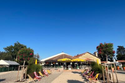 Tables élégamment dressées avec nappes blanches, serviettes pliées, verres et décorations florales dans une salle lumineuse.