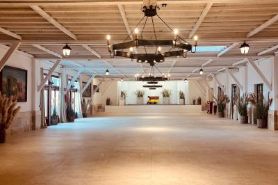 Tables élégamment dressées avec nappes blanches, serviettes pliées, verres et décorations florales dans une salle lumineuse.