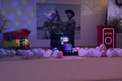 Tables élégamment dressées avec nappes blanches, serviettes pliées, verres et décorations florales dans une salle lumineuse.