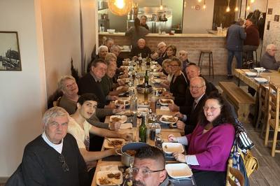 Toilettes modernes avec lavabo, miroir, distributeurs de savon et carrelage blanc et gris.