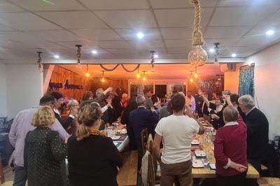 Toilettes modernes avec lavabo, miroir, distributeurs de savon et carrelage blanc et gris.