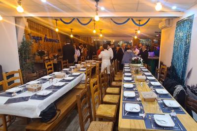 Toilettes modernes avec lavabo, miroir, distributeurs de savon et carrelage blanc et gris.