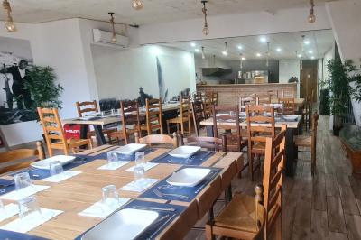 Toilettes modernes avec lavabo, miroir, distributeurs de savon et carrelage blanc et gris.