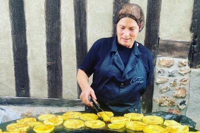Buffet avec viennoiseries, fruits, jus et café, disposé sur une table recouverte d'une nappe rouge à carreaux.