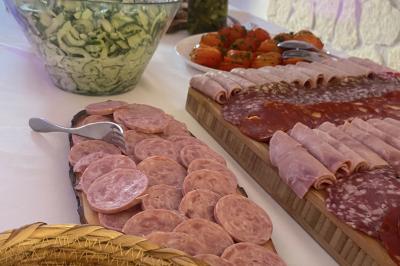 Buffet avec viennoiseries, fruits, jus et café, disposé sur une table recouverte d'une nappe rouge à carreaux.