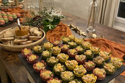 Buffet avec viennoiseries, fruits, jus et café, disposé sur une table recouverte d'une nappe rouge à carreaux.