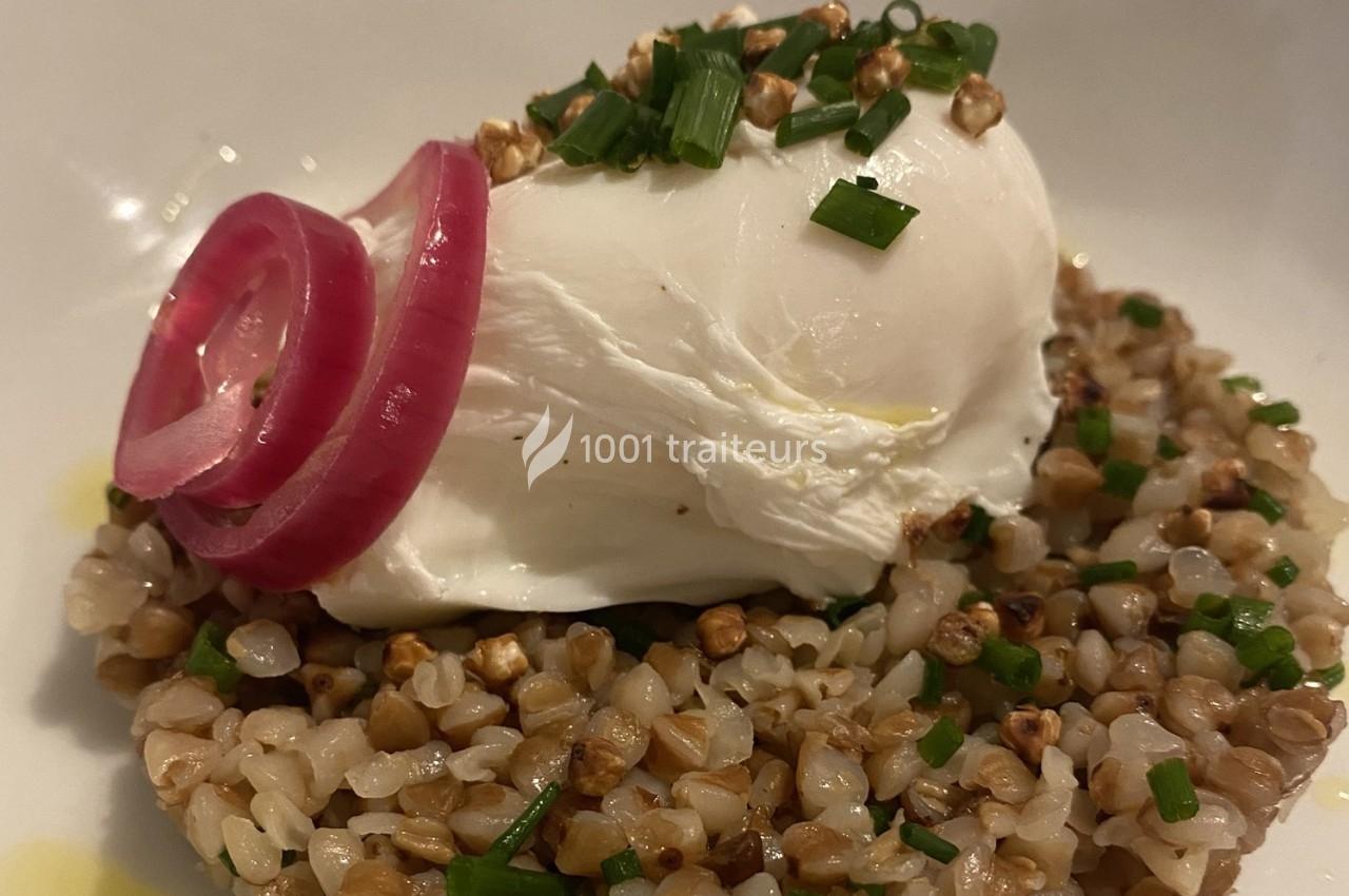 Assiette de sarrasin garni d'un œuf poché, d'oignons rouges marinés et de ciboulette hachée.