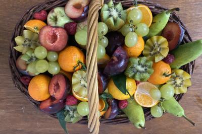 Buffet avec viennoiseries, fruits, jus et café, disposé sur une table recouverte d'une nappe rouge à carreaux.