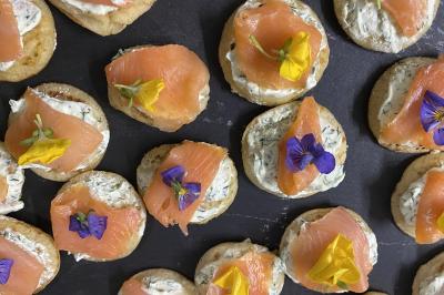 Buffet avec viennoiseries, fruits, jus et café, disposé sur une table recouverte d'une nappe rouge à carreaux.