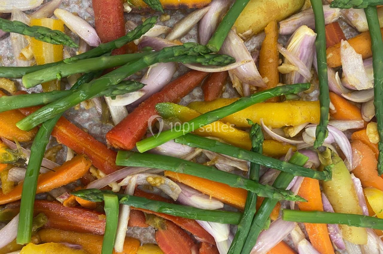 Légumes colorés, dont carottes, asperges et échalotes, disposés sur une plaque de cuisson.