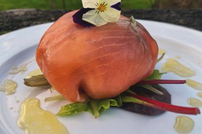 Buffet avec viennoiseries, fruits, jus et café, disposé sur une table recouverte d'une nappe rouge à carreaux.
