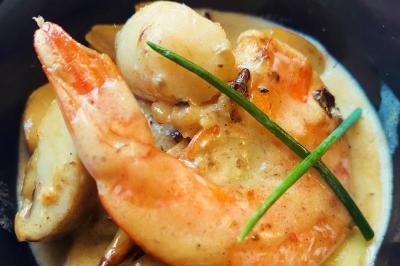 Crevette et noix de Saint-Jacques dans une sauce crémeuse, garnies de brins de ciboulette.