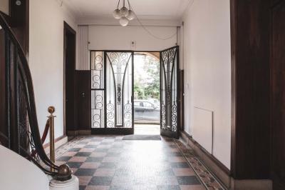 Salle lumineuse décorée pour un événement, avec des tables dressées, des chaises dorées et des fleurs en centre de table.