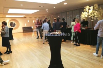 Terrasse extérieure avec pelouse artificielle, pergola couverte et immeubles en arrière-plan par temps ensoleillé.