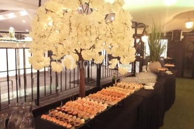 Terrasse extérieure avec pelouse artificielle, pergola couverte et immeubles en arrière-plan par temps ensoleillé.