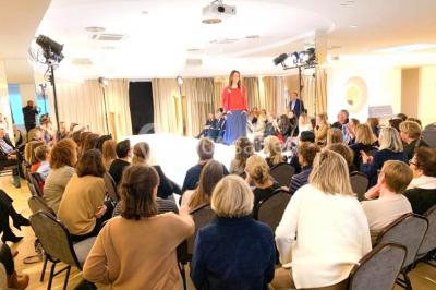 Terrasse extérieure avec pelouse artificielle, pergola couverte et immeubles en arrière-plan par temps ensoleillé.