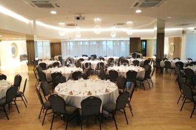 Terrasse extérieure avec pelouse artificielle, pergola couverte et immeubles en arrière-plan par temps ensoleillé.