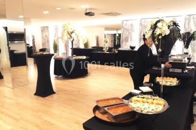 Terrasse extérieure avec pelouse artificielle, pergola couverte et immeubles en arrière-plan par temps ensoleillé.