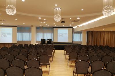 Terrasse extérieure avec pelouse artificielle, pergola couverte et immeubles en arrière-plan par temps ensoleillé.