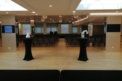 Terrasse extérieure avec pelouse artificielle, pergola couverte et immeubles en arrière-plan par temps ensoleillé.