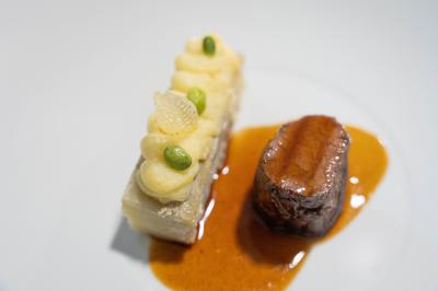 Plat gastronomique composé d'un morceau de viande nappé de sauce et d'un accompagnement de pommes de terre dressées…