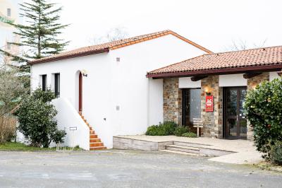 Table élégamment dressée avec nappes blanches, verres, couverts, bouquets de fleurs et petits pots décoratifs.