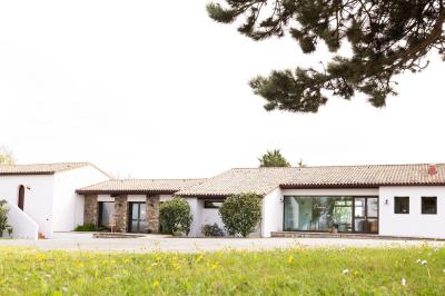 Table élégamment dressée avec nappes blanches, verres, couverts, bouquets de fleurs et petits pots décoratifs.
