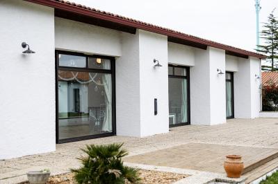 Table élégamment dressée avec nappes blanches, verres, couverts, bouquets de fleurs et petits pots décoratifs.