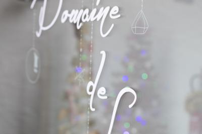 Table élégamment dressée avec nappes blanches, verres, couverts, bouquets de fleurs et petits pots décoratifs.