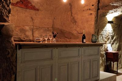 Canapé en velours brun devant une grande fenêtre lumineuse, entouré de rideaux beiges et de meubles en bois.