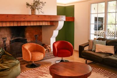 Mobilier de jardin en bois avec coussins blancs, comprenant un canapé, deux fauteuils et une table basse, sur pelouse.