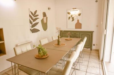 Mobilier de jardin en bois avec coussins blancs, comprenant un canapé, deux fauteuils et une table basse, sur pelouse.